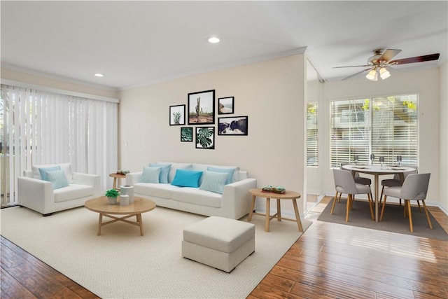 living room featuring hardwood / wood-style flooring, ornamental molding, and ceiling fan