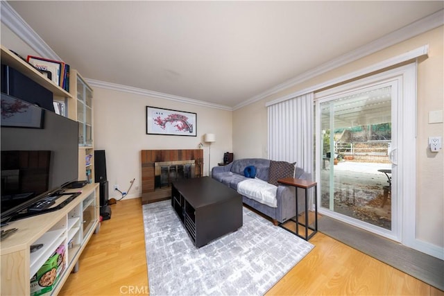 living room featuring crown molding, a fireplace, and hardwood / wood-style floors