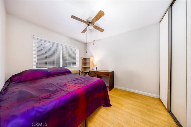 bedroom with ceiling fan, light hardwood / wood-style floors, and a closet