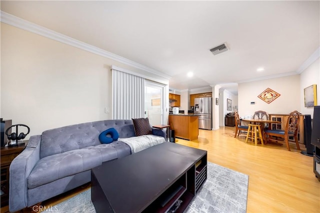 living room featuring ornamental molding and light hardwood / wood-style floors