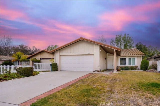 ranch-style house with a garage and a lawn