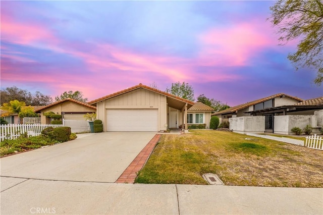 single story home featuring a garage and a lawn