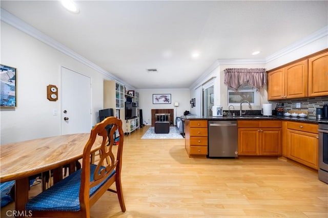 kitchen with sink, light hardwood / wood-style flooring, appliances with stainless steel finishes, tasteful backsplash, and ornamental molding