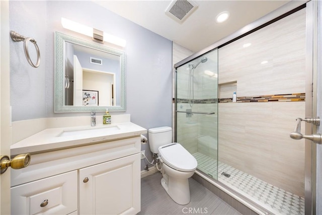 bathroom with a shower with door, vanity, and toilet