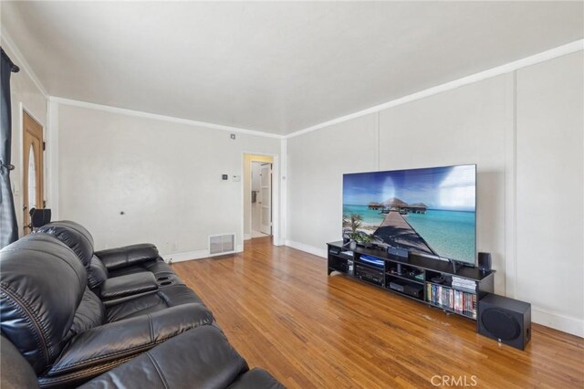 living room with hardwood / wood-style flooring and ornamental molding