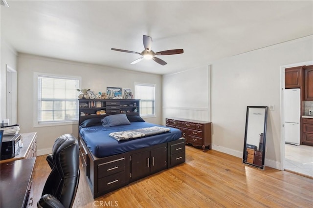 bedroom with light hardwood / wood-style floors, ceiling fan, and white refrigerator