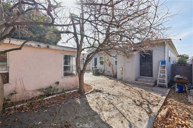 rear view of house featuring central AC unit and a patio