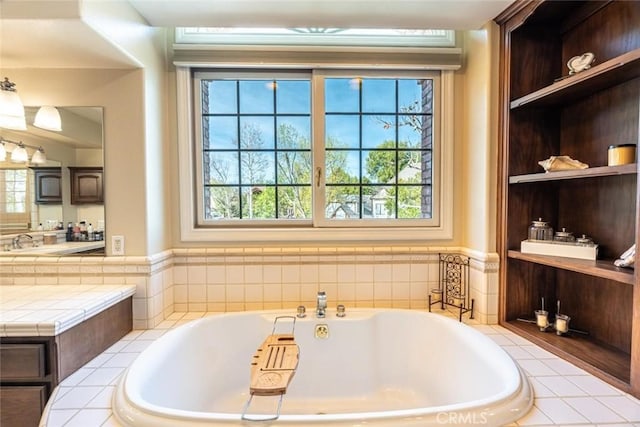 bathroom with tiled bath and vanity