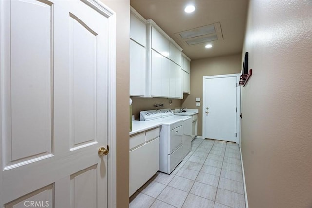 clothes washing area with sink, light tile patterned floors, washer and clothes dryer, and cabinets