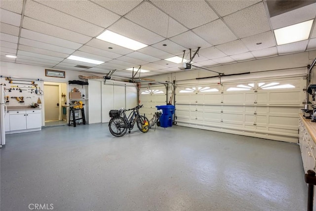 garage with white fridge and a garage door opener