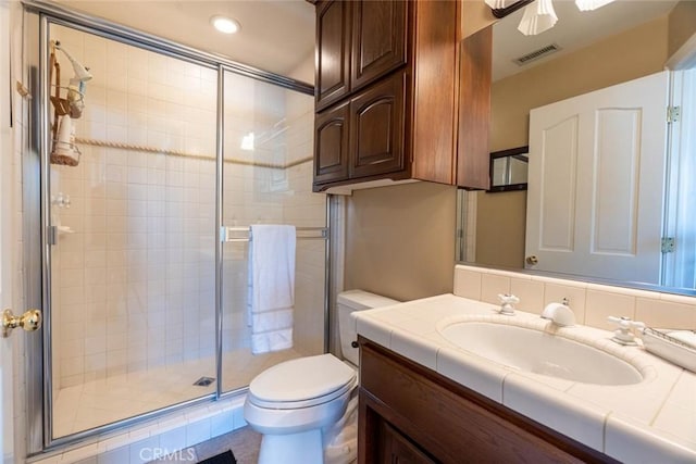 bathroom with toilet, a shower with door, and vanity