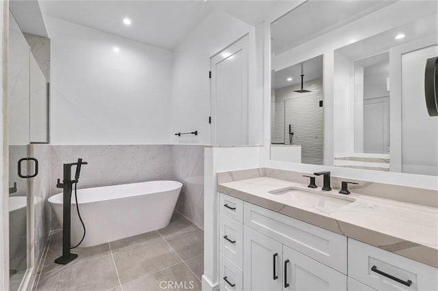 bathroom with vanity, tile patterned floors, plus walk in shower, and tile walls