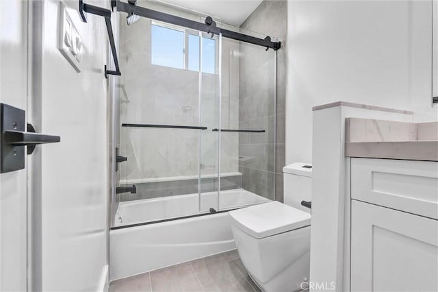 bathroom featuring tile patterned floors, shower / bath combination with glass door, and toilet