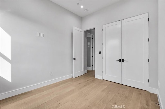 unfurnished bedroom with light hardwood / wood-style floors and a closet