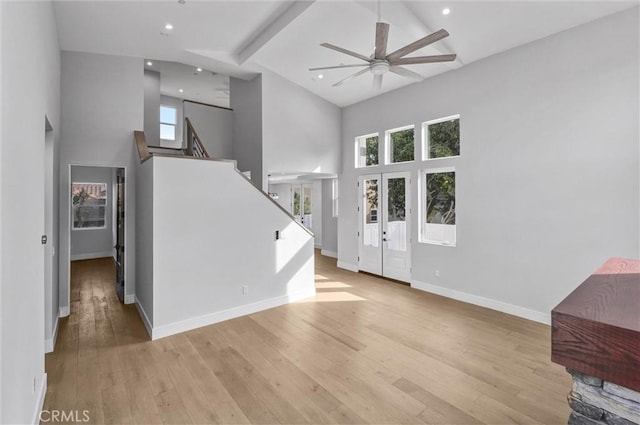 foyer entrance featuring beamed ceiling, ceiling fan, high vaulted ceiling, and light wood-type flooring