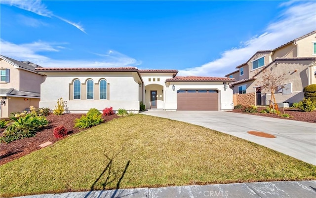 mediterranean / spanish home with a garage and a front lawn