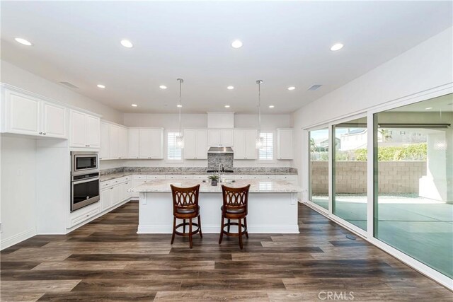 12430 Altura Dr, Rancho Cucamonga, CA 91739 - kitchen featuring white cabinetry, an island with sink, hanging light fixtures, light stone counters, and stainless steel appliances