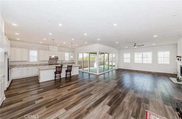 12430 Altura Dr, Rancho Cucamonga, CA 91739 - kitchen with hanging light fixtures, an island with sink, white cabinets, and a kitchen bar