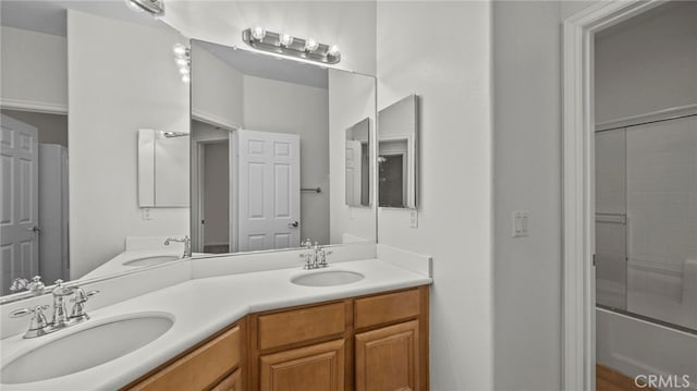 bathroom with vanity and shower / bath combination with glass door