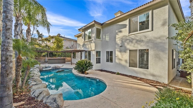 view of swimming pool with a jacuzzi and a patio