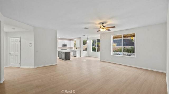 unfurnished living room with ceiling fan and light hardwood / wood-style floors