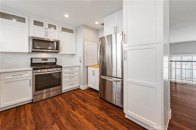 kitchen with dark hardwood / wood-style flooring, stainless steel appliances, and white cabinets