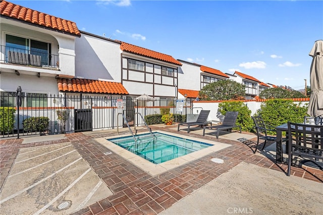 view of pool with a patio and a community hot tub