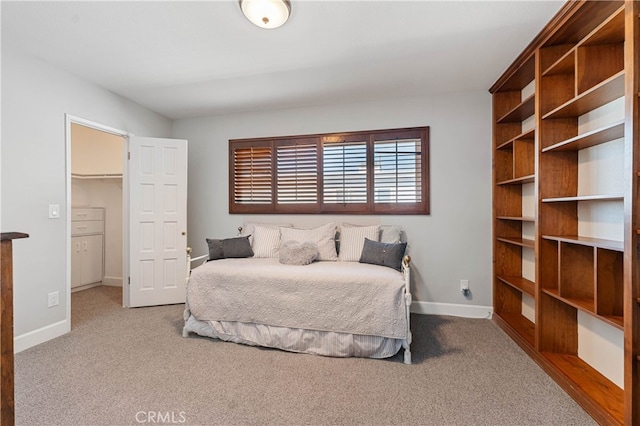 bedroom with a walk in closet and carpet