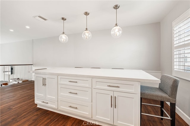 kitchen featuring white cabinetry, hanging light fixtures, and dark hardwood / wood-style flooring