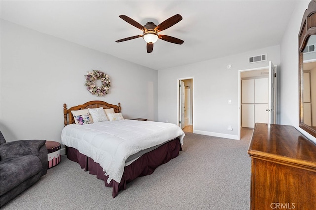 bedroom with ensuite bathroom, ceiling fan, and carpet flooring