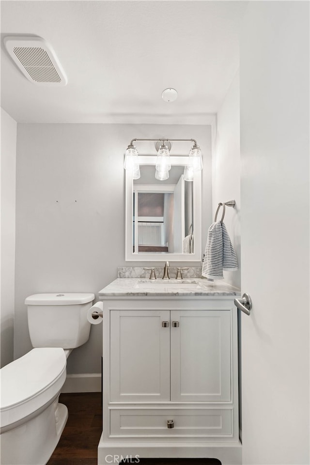 bathroom with vanity, wood-type flooring, and toilet