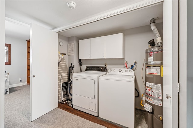 washroom featuring water heater, washing machine and dryer, and cabinets