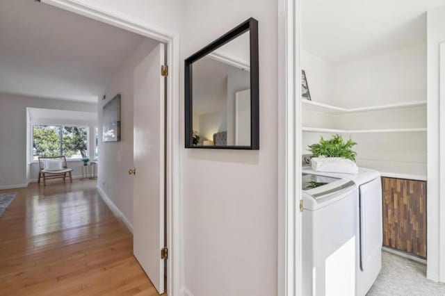 hallway with washing machine and dryer and light hardwood / wood-style floors