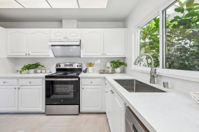 kitchen featuring sink, light tile patterned floors, white cabinets, and appliances with stainless steel finishes