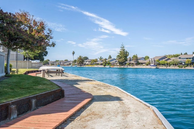 view of pool with a lawn and a water view