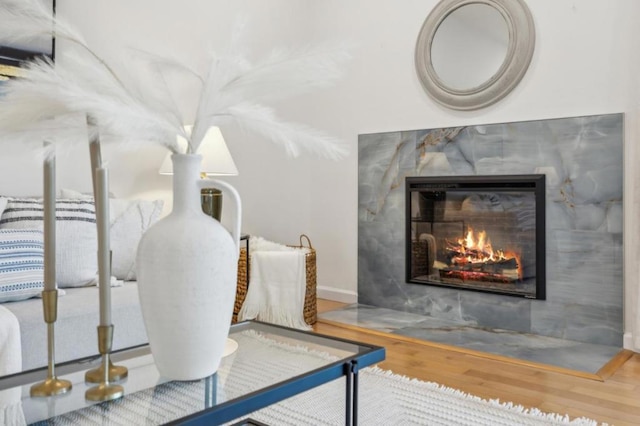 bedroom featuring a tiled fireplace and wood-type flooring