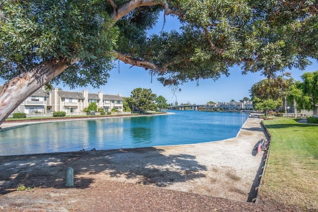 view of swimming pool with a water view and a yard