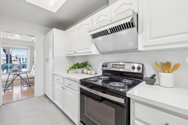 kitchen featuring white cabinetry, range hood, black range with electric cooktop, and light tile patterned floors