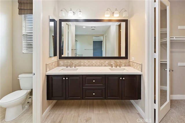 bathroom featuring vanity, backsplash, and toilet