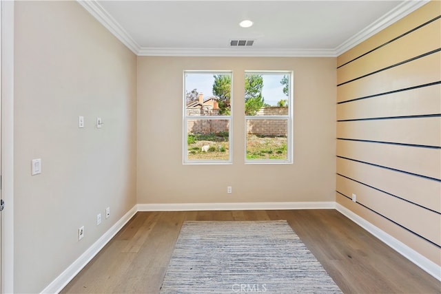 spare room featuring crown molding and light hardwood / wood-style flooring