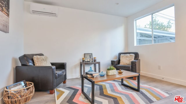 living area with light hardwood / wood-style flooring and a wall unit AC