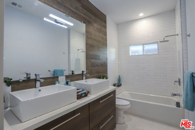 full bathroom with tiled shower / bath, vanity, toilet, and tile patterned flooring