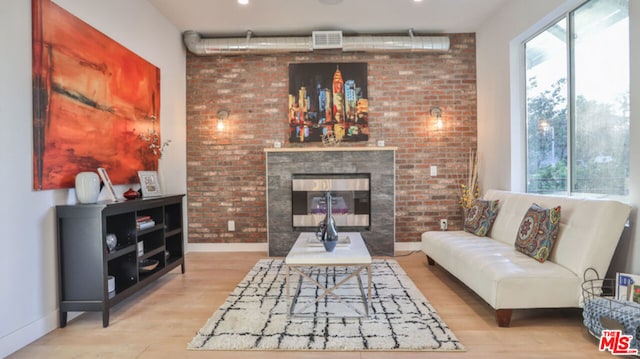 living room with a multi sided fireplace, plenty of natural light, and light hardwood / wood-style flooring