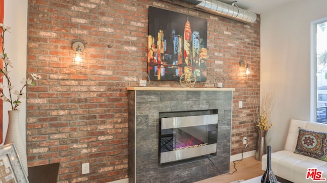 living room featuring hardwood / wood-style floors and a brick fireplace