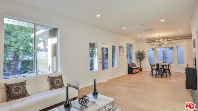 living room featuring light hardwood / wood-style flooring and a chandelier