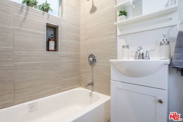 bathroom with tiled shower / bath and vanity