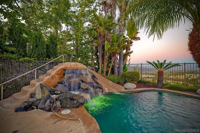 pool at dusk with pool water feature