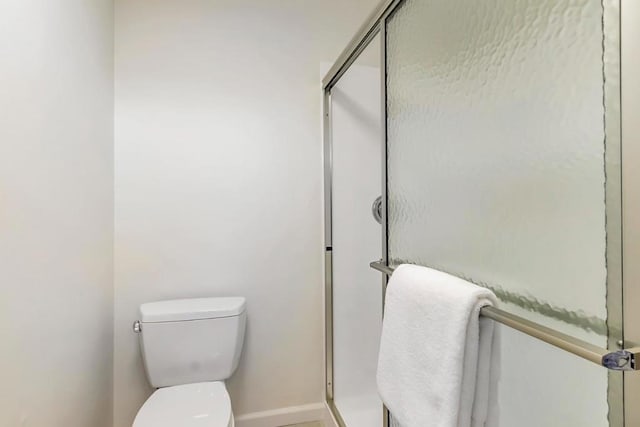 bathroom with walk in shower and toilet