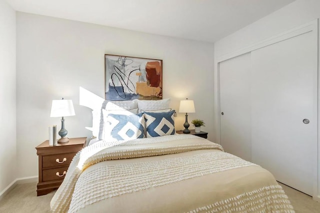 bedroom with light colored carpet and a closet