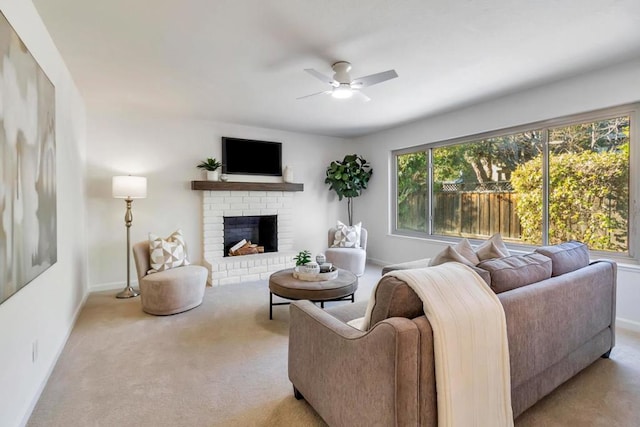 living room with a brick fireplace, light carpet, and ceiling fan